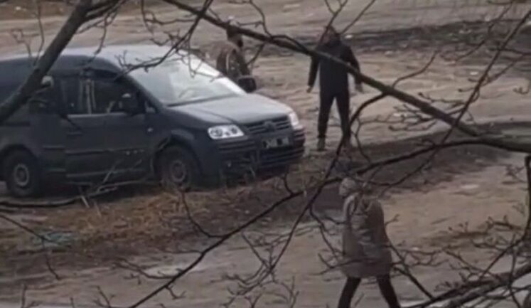 People in military uniforms near minibus beat man with their feet and struck him to ground. VIDEO