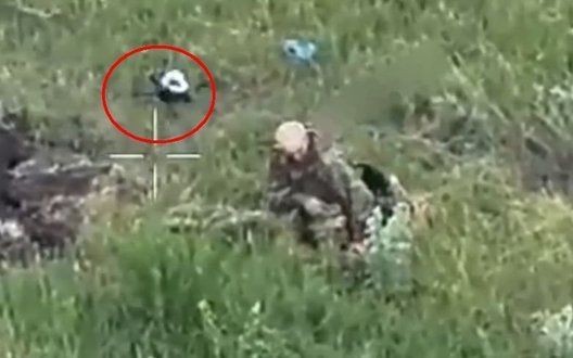Російський штурмовик серед забур’яненого поля знімає шолом, 