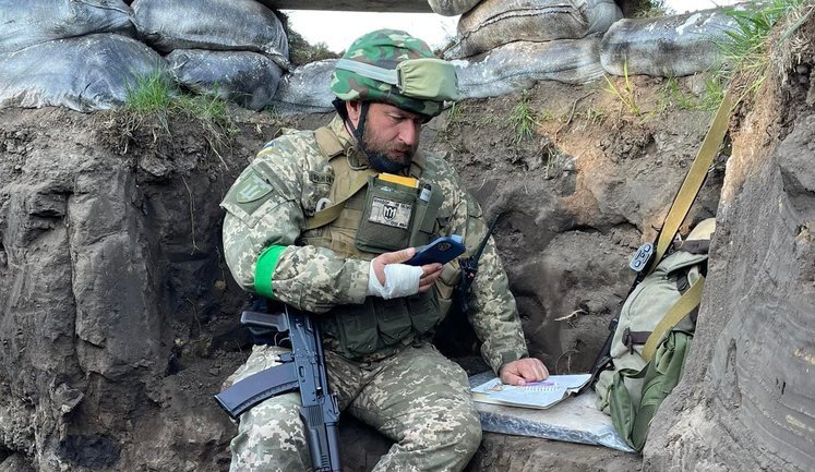 University Professor Sandor giving a lecture to students from a trench. PHOTO