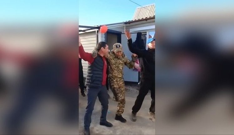 One-legged "hero of special military operation" in military uniform with letter "V" on his cap returned home and dances in yard with fellow villagers. VIDEO