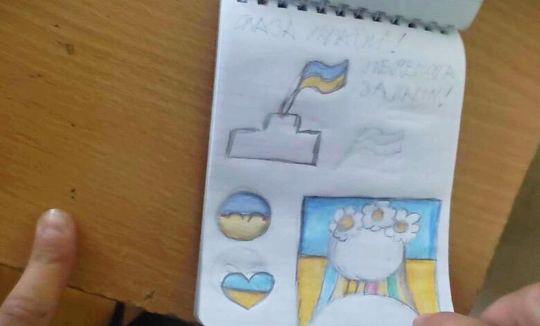Девочка из Херсона, семья которой вынужденно эвакуировалась в Крым, отказывается в школе петь гимн оккупантов и нарисовала патриотический рисунок с лозунгом Слава Украине 01