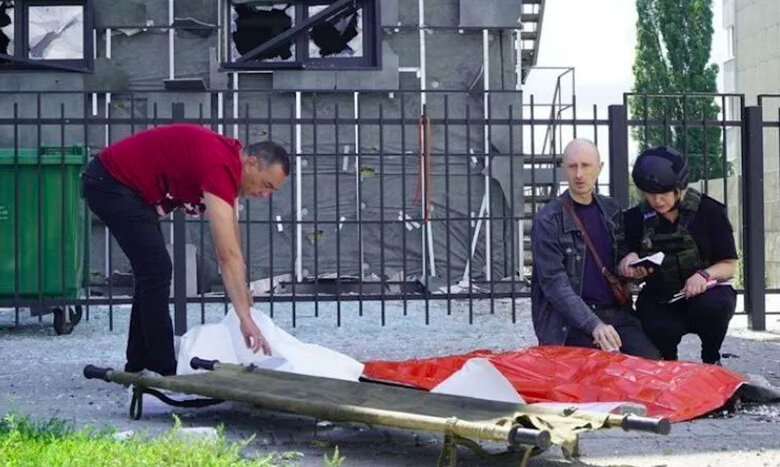 Father holds hand of his 13-year-old son killed by Russians in Kharkiv 01