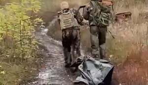 Two occupiers drag their "KIA" in black bag along a field road: "Didn’t quite make it. May he rest in heaven.". VIDEO