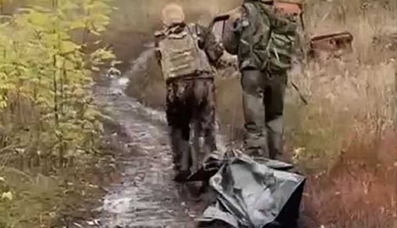 Двое оккупантов тащат по полевой дороге своего "двухсотого" в черном мешке: "Не дошел чуть-чуть. Царство небесное". ВИДЕО