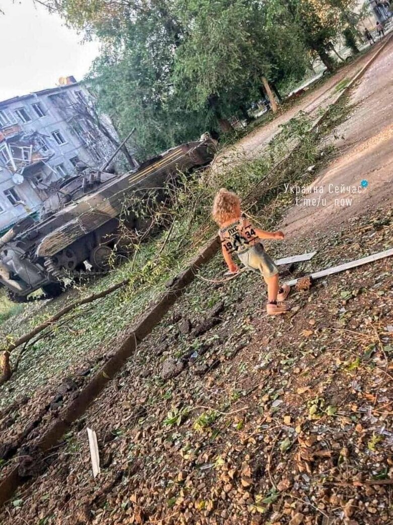 Ребенок играет во дворе Северодонецка вблизи разбитого танка рашистов 01