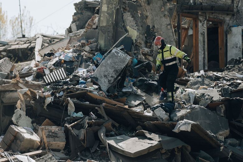 Rescuers clear the rubble at the site of a Russian missile strike