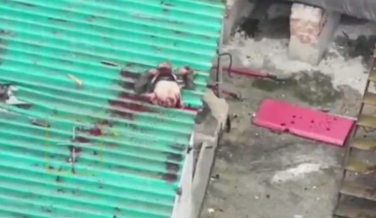 Верхняя часть оккупанта залетела на крышу сарайчика после удара дрона, лежит там и дергается. ВИДЕО 18+