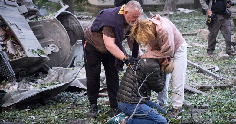 подружжя біля зруйнованого будинку у Києві