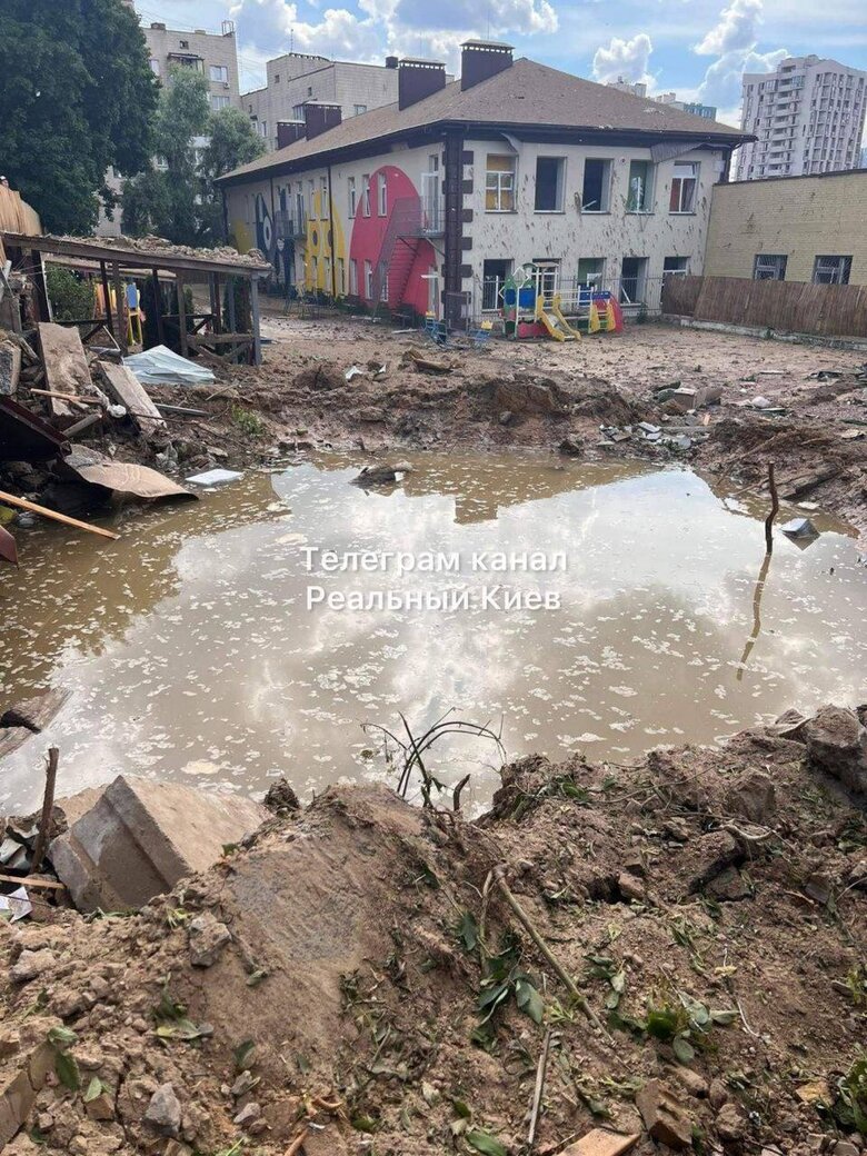 Pit from enemy missile hitting playground near kindergarten in Kyiv 01