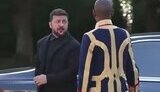 Zelenskyy in a suit and a man in livery