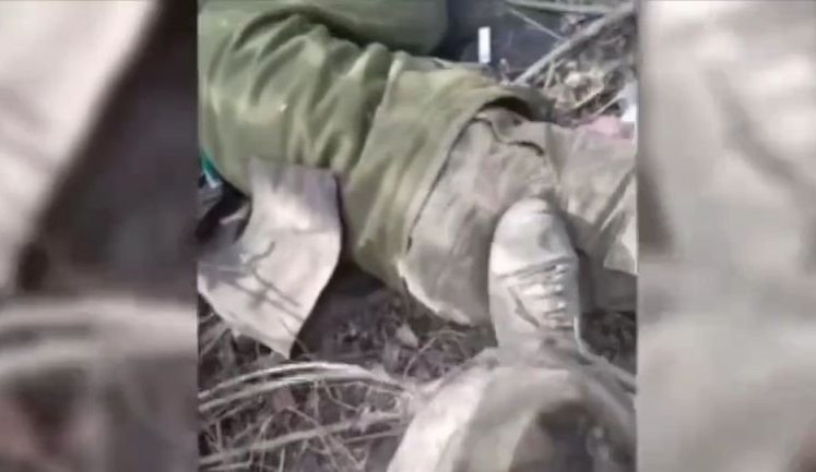 Окупант штурхає ногою та добиває двома пострілами пораненого беззбройного українського воїна. ВIДЕО 18+
