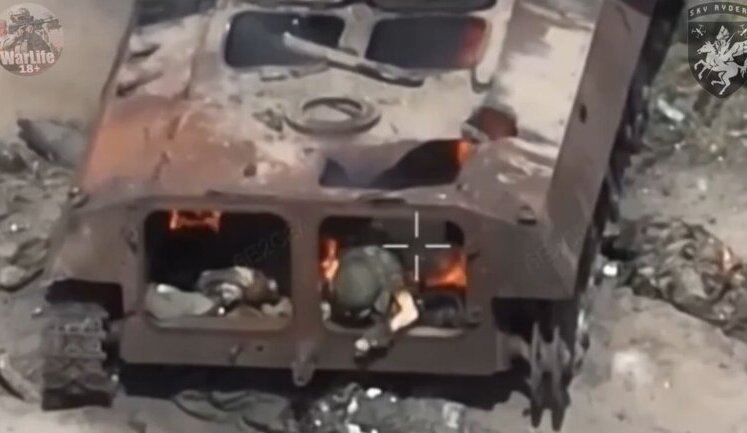 Engulfed in flames, occupier trying in vain to climb out of burning armoured vehicle. VIDEO 18+