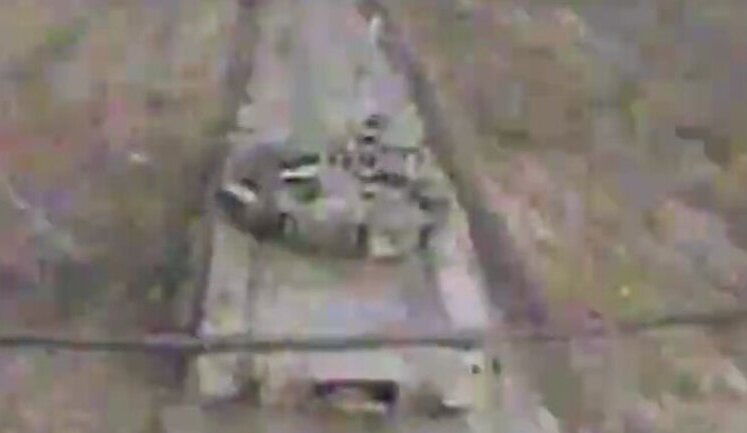 Ukrainian kamikaze drone flies into open hatch of enemy tank moving along road. VIDEO