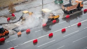 Київські комунальники кладуть асфальт під сильною зливою. ФОТОрепортаж+ВІДЕО (оновлено)