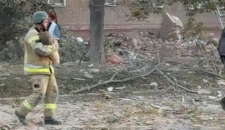 Рятувальник несе дитину, яку витягли із зруйнованої російським ударом багатоповерхівки у Прилуках. ВIДЕО