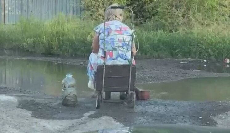 Донбас без води: літня жінка черпає її з калюжі. ВIДЕО