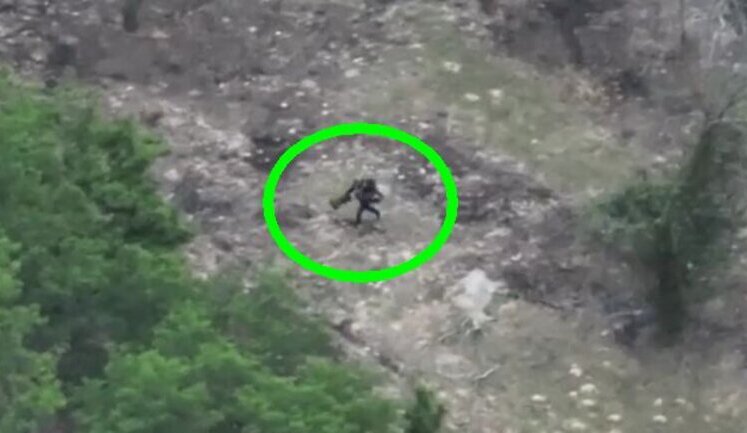 Occupier in wetsuit and flippers is running through forest, trying in vain to escape from kamikaze drone. VIDEO