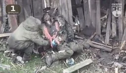 росіянин обшукує поплічника пораненого