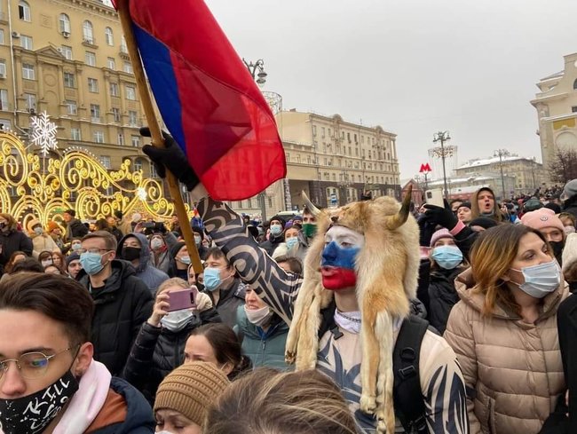 Хлопець на акції за Навального копіює рогатого шамана QAnon, який штурмував Капітолій США 01