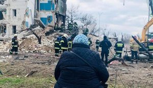 Жінка в Бородянці третю добу чекає, коли з-під завалів витягнуть її сім'ю. Рятувальники принесли їй стілець. ФОТО ДНЯ