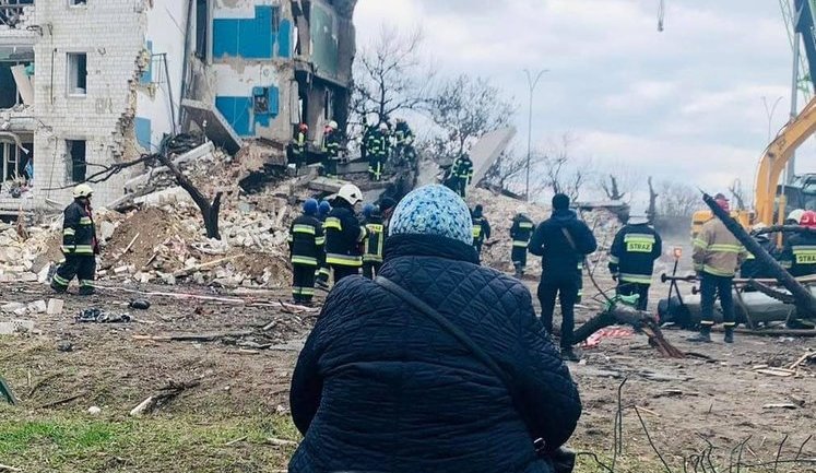 Жінка в Бородянці третю добу чекає, коли з-під завалів витягнуть її сім'ю. Рятувальники принесли їй стілець. ФОТО ДНЯ