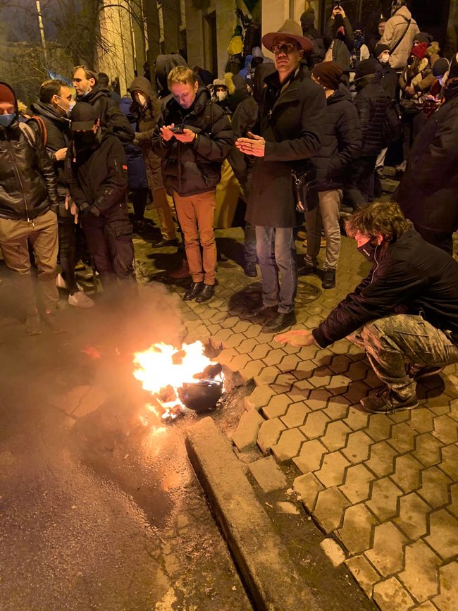Протестувальники під Офісом Президента гріються від охопленого вогнем поліцейського шолома. ФОТО дня 01