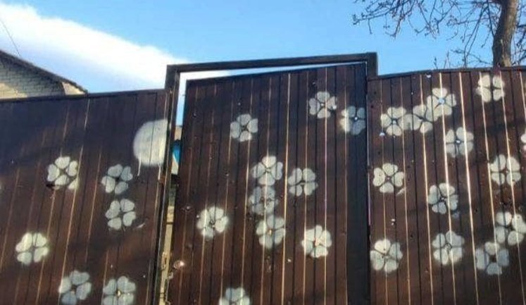 "Ми кулі перетворимо на квіти": жителі Гостомеля оригінально декорують сліди від пострілів на паркані. ФОТО