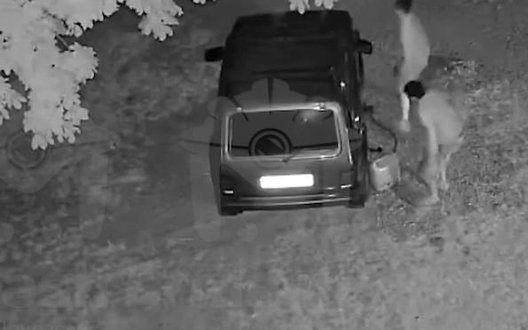 Двоє чоловіків уночі зливають пальне із припаркованого автом