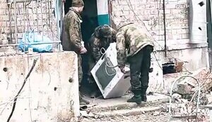 Трое оккупантов несут стиральную машинку по улице оккупированной и разрушенной Авдеевки. ВИДЕО