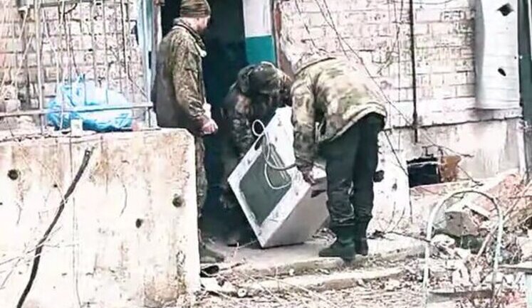 Трое оккупантов несут стиральную машинку по улице оккупированной и разрушенной Авдеевки. ВИДЕО