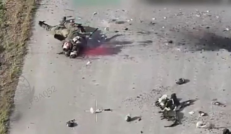 Росіянин лежить на асфальті у калюжі власної крові після влучання українського дрона-камікадзе. ВIДЕО 18+