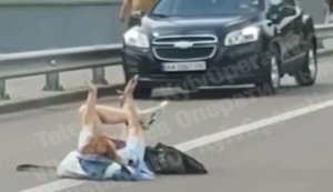 "Активне сонячне випромінювання не на всіх нормально впливає", - в районі київського Гідропарку дівчина в шортах вляглася посеред дороги. ВIДЕО