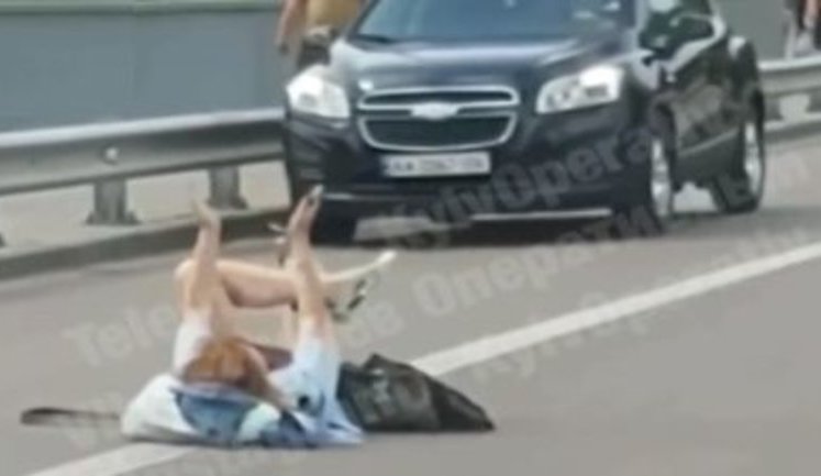 "Активне сонячне випромінювання не на всіх нормально впливає", - в районі київського Гідропарку дівчина в шортах вляглася посеред дороги. ВIДЕО
