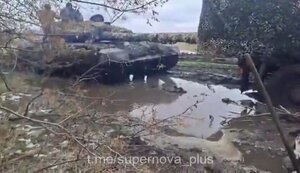 Танкисты помогают вытолкать из грязи погрязший туда грузовик. ВИДЕО