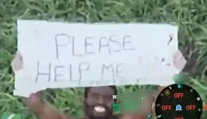 African mercenary in Russian army walks naked across battlefield with "Please help me" sign.. VIDEO
